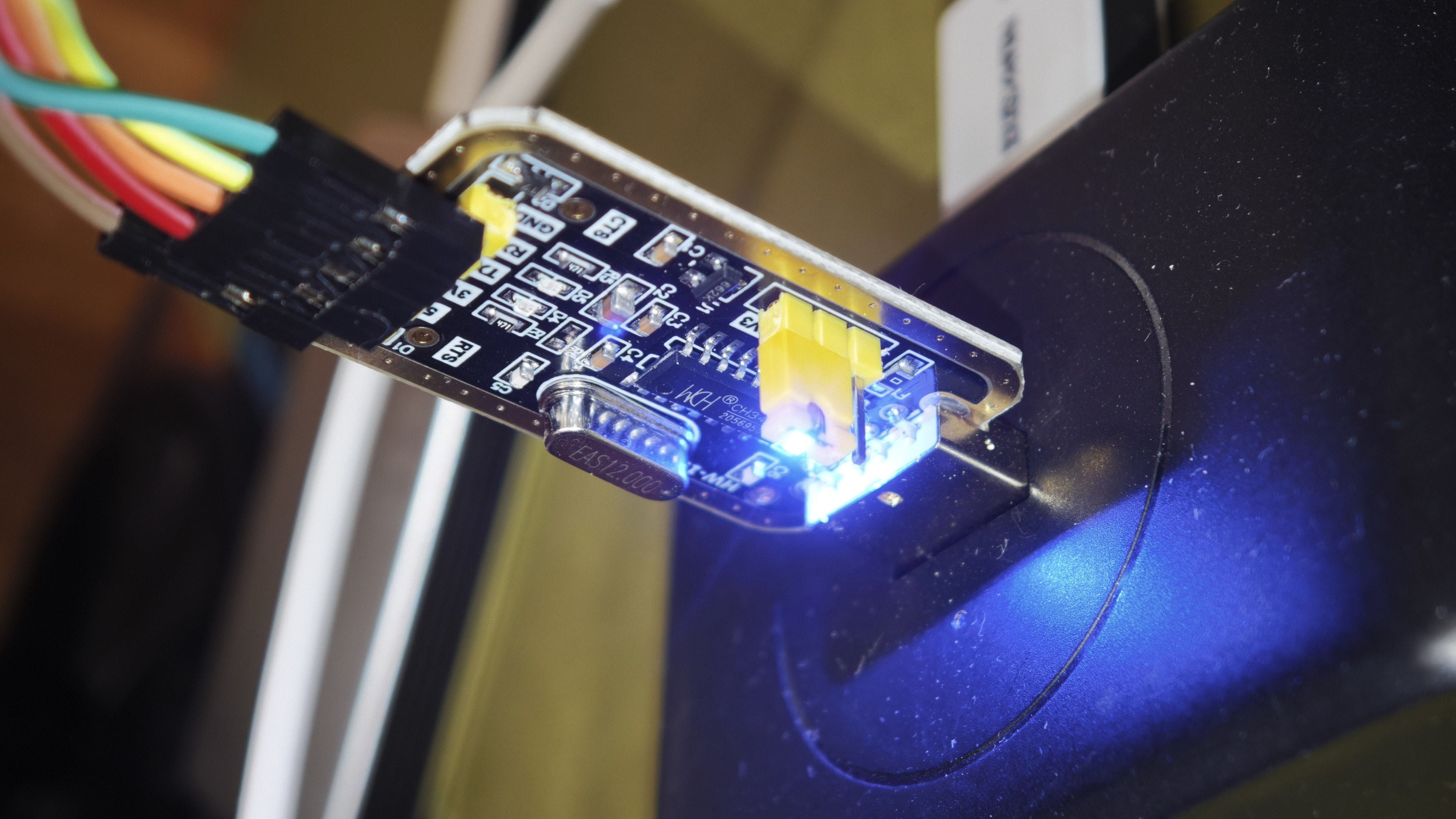 CH340G 型 USB 转 TTL 小板特写,引出针脚标着 5V、3V3、TXD、RXD、GND,板上另有 12MHz 晶振