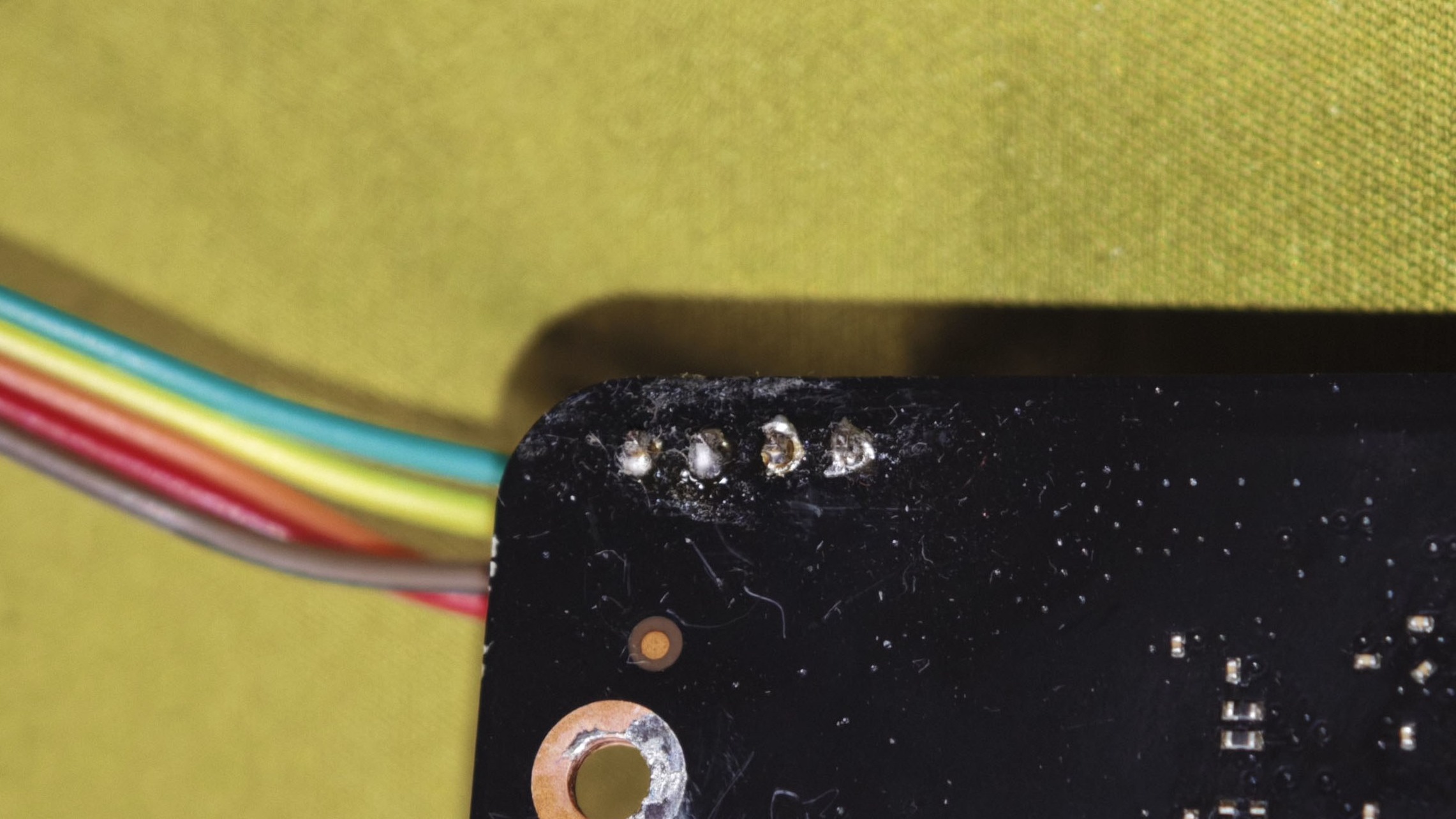 T36 Max 主板 JP1 焊盘焊接完成后的特写,四根细线分别焊在四个焊点上