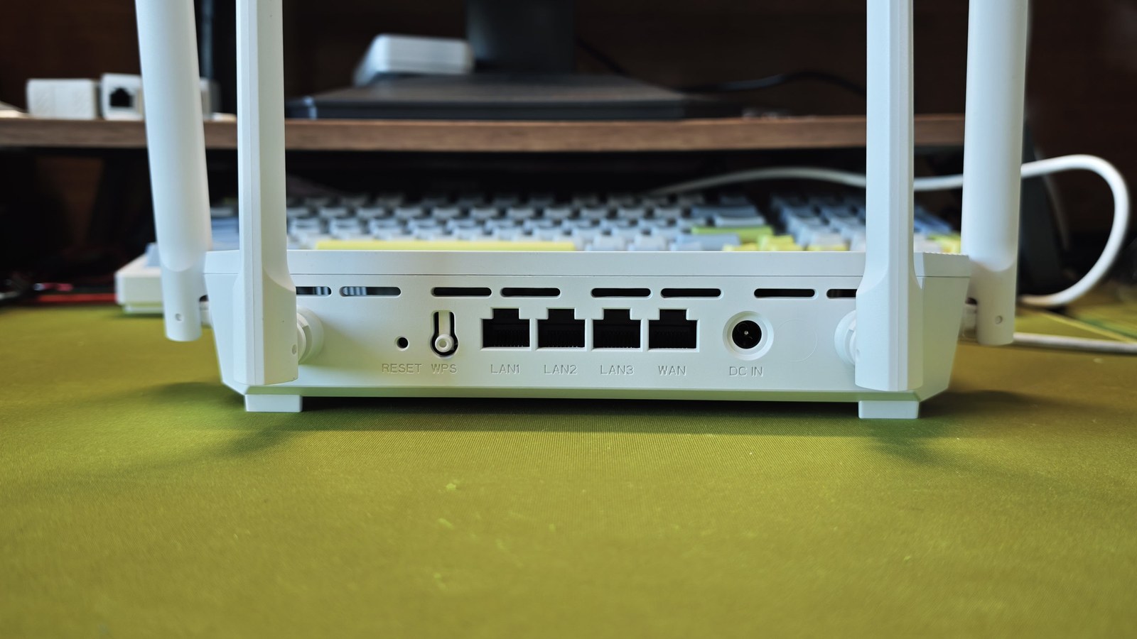 T36 Max 背部接口,从左到右为 RESET 小孔、WPS 按键、LAN1 至 LAN3 三个千兆网口、WAN 口和 12V 电源口