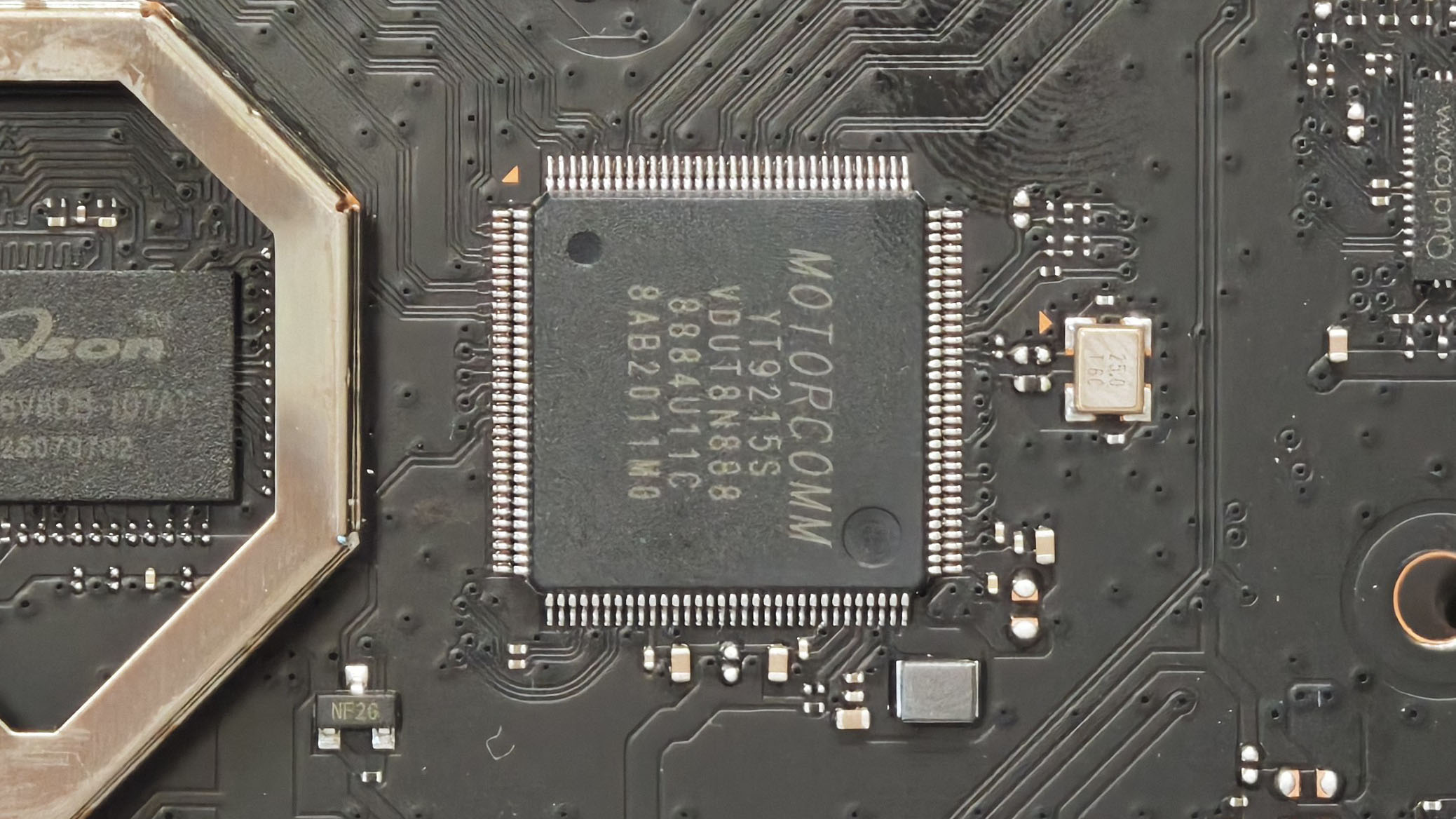 小米 BE3600 千兆交换芯片特写,丝印为 MOTORCOMM YT9215S,旁边是 25MHz 晶振